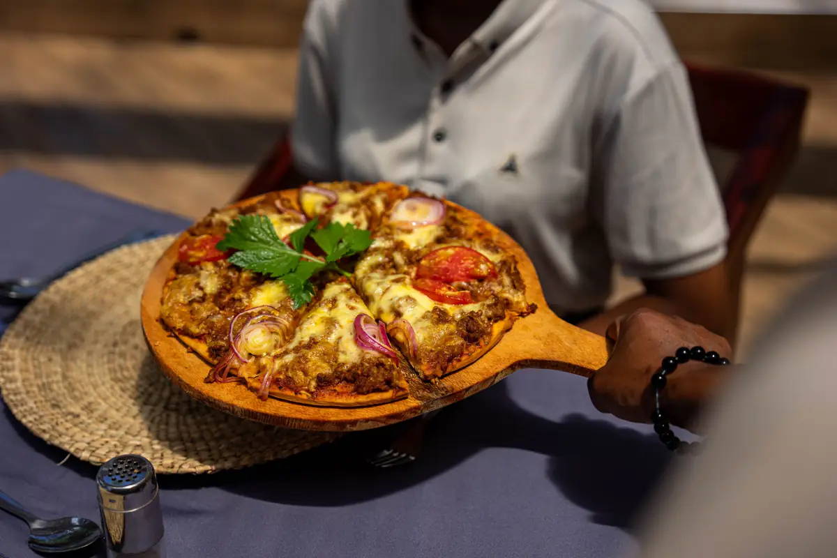 Pizza served at the table at Mvuli Farm Lodge